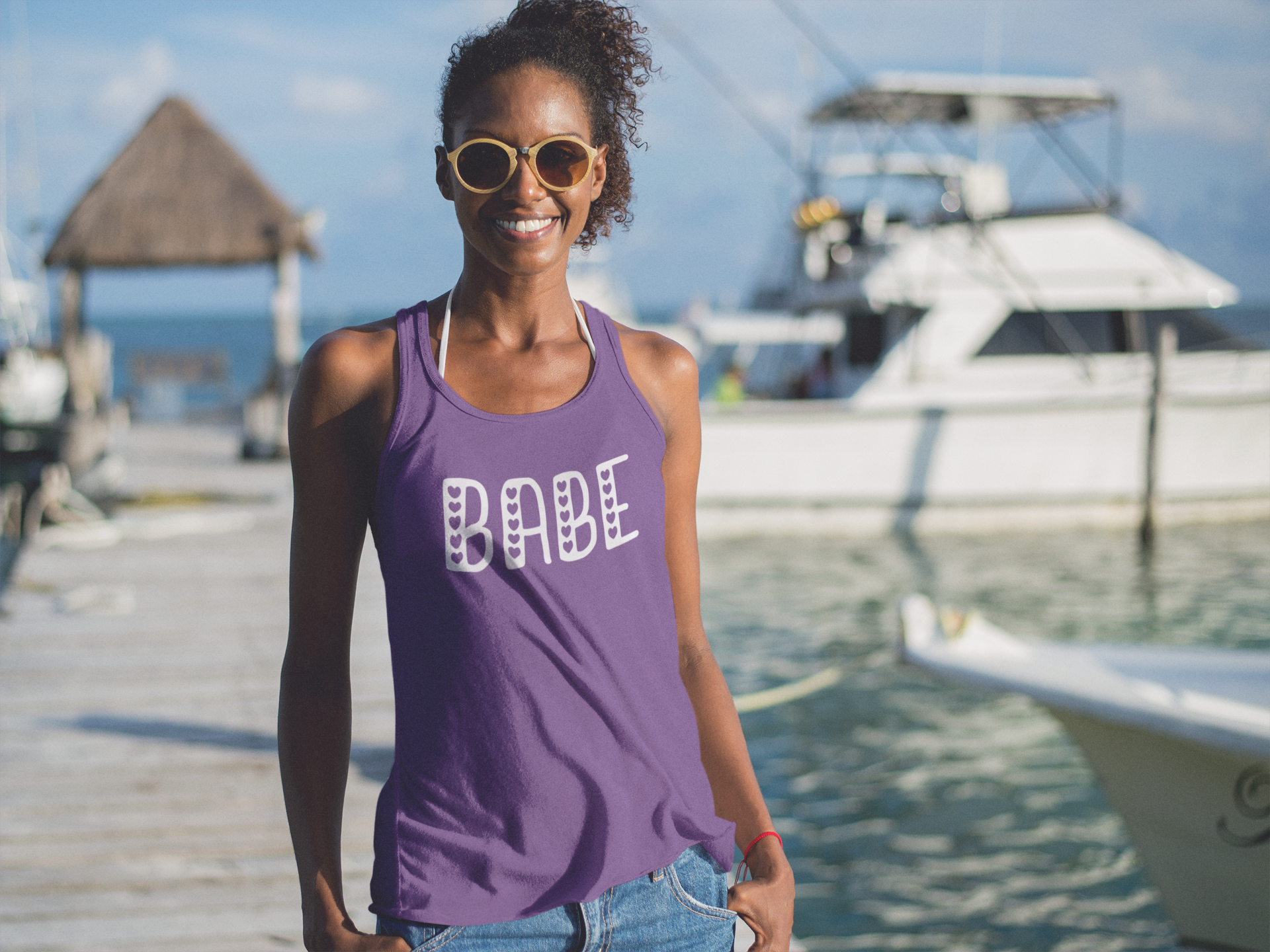 young woman wearing babe tank top at a pier