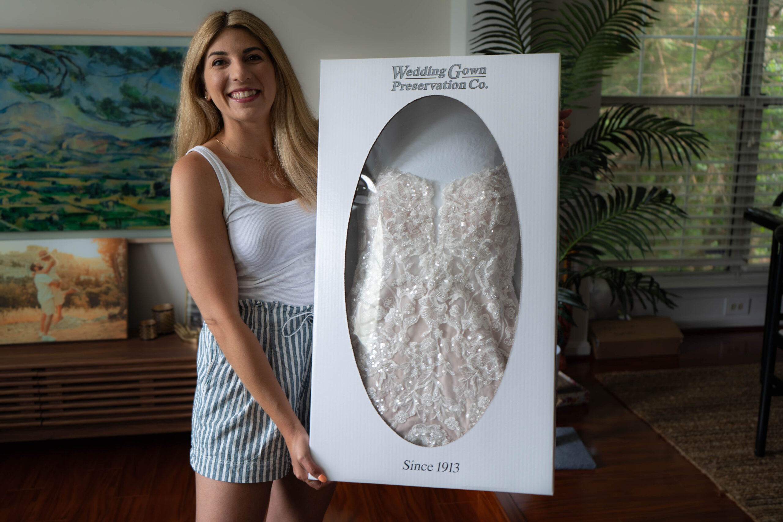 woman holding her preserved bridal gown from Wedding Gown Preservation Co